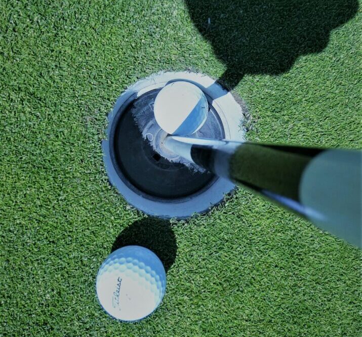 Golf putting turf with golf ball in hole